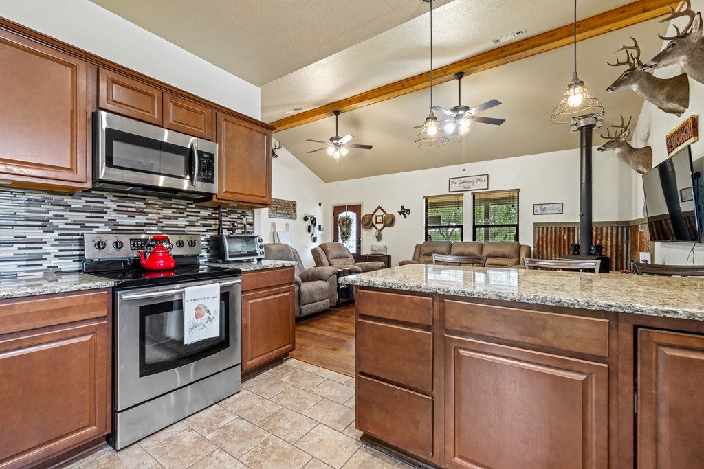 221 Coyote Trail Harper, TX 78631 - Photo 7 of 47 a kitchen with stainless steel appliances granite countertop a sink and cabinets