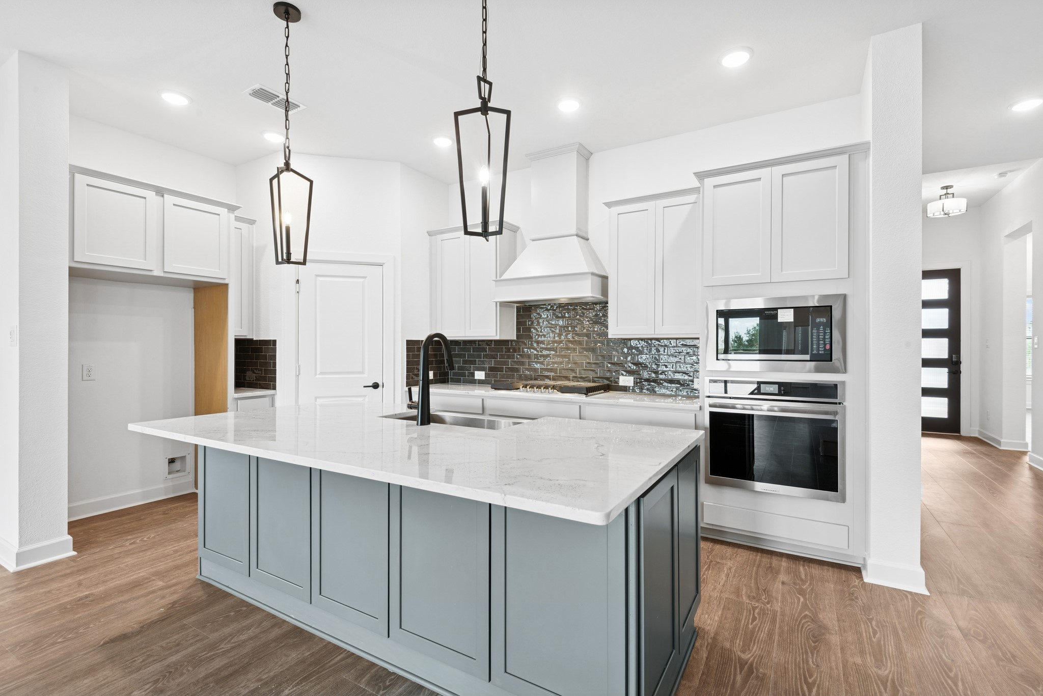 5510 Orangery Lane Manvel, TX 77578 - Photo 22 of 48 a kitchen with stainless steel appliances kitchen island granite countertop a stove a sink a refrigerator and white cabinets with wooden floor