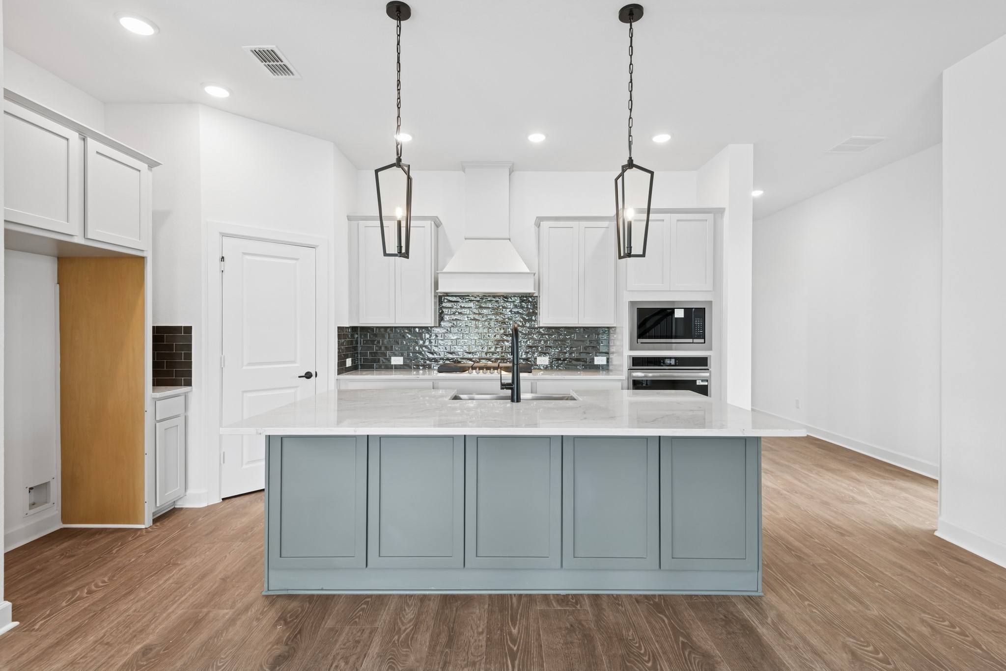 5510 Orangery Lane Manvel, TX 77578 - Photo 23 of 48 a kitchen with kitchen island white cabinets and refrigerator