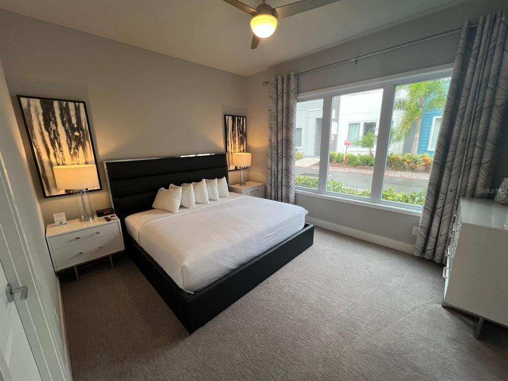 7770 Sandy Ridge Drive, Unit 126 Reunion, FL 34747 - Photo 6 of 33 a bedroom with a bed and a large window with balcony view