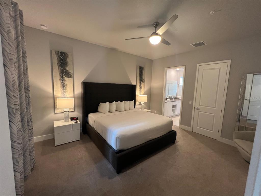 7770 Sandy Ridge Drive, Unit 126 Reunion, FL 34747 - Photo 7 of 33 a spacious bedroom with a bed and a refrigerator