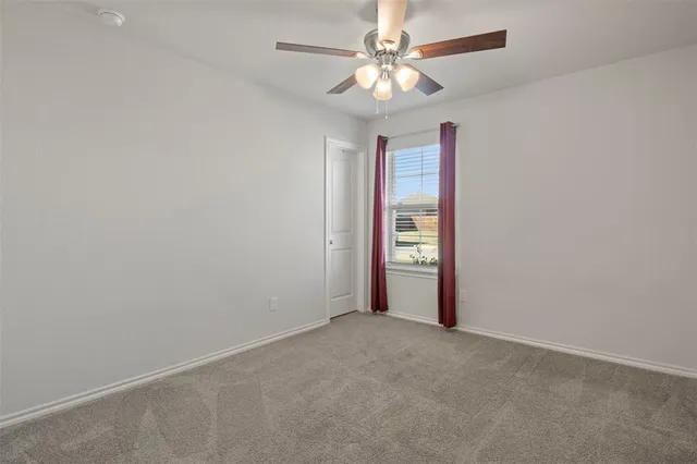 an empty room with closet and a chandelier fan