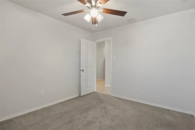 an empty room with closet and a chandelier fan