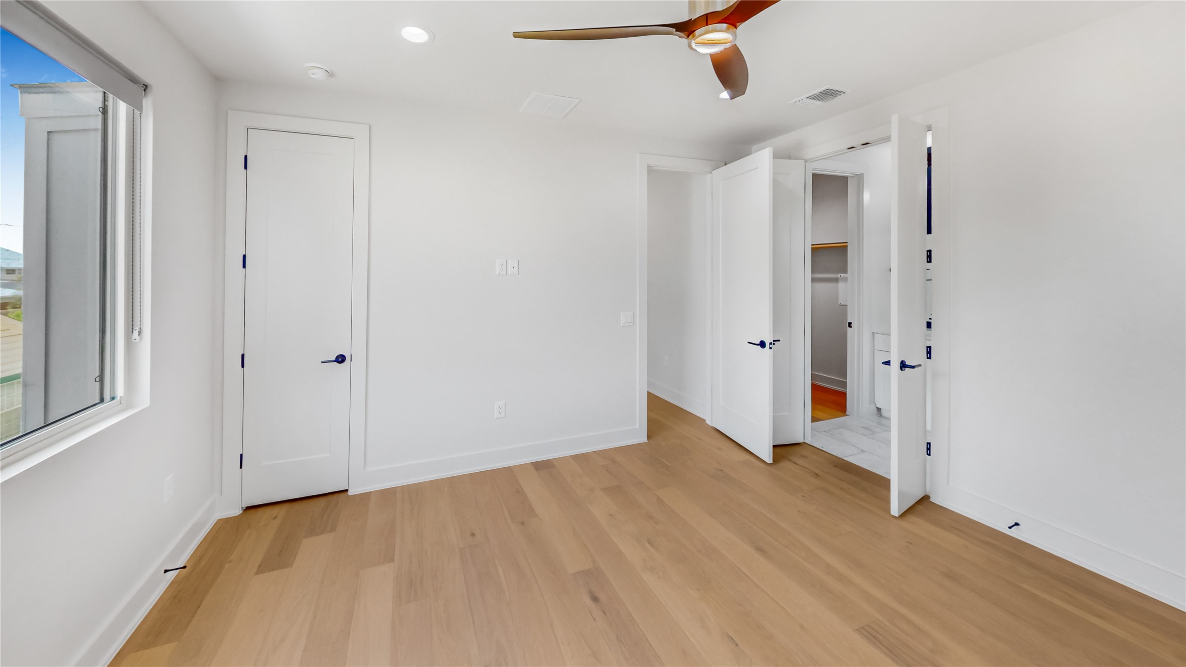 4424 Hank Avenue, Unit 2 Austin, TX 78745 - Photo 8 of 11 Blonde wood flooring and a wide window with a serene outlook create an airy, tranquil atmosphere.