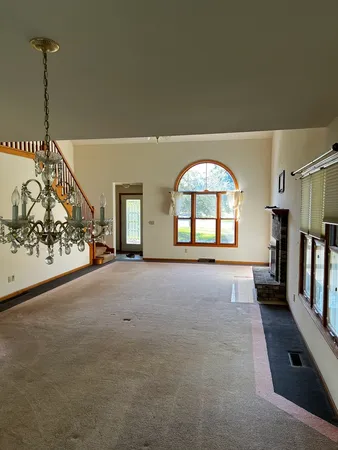 a view of an empty room with a fireplace and a window