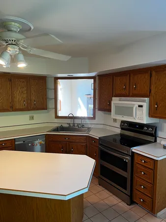 a kitchen with stainless steel appliances granite countertop a stove a sink and a microwave