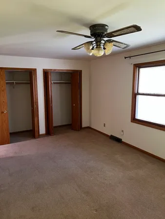 a view of a livingroom with a ceiling fan and window