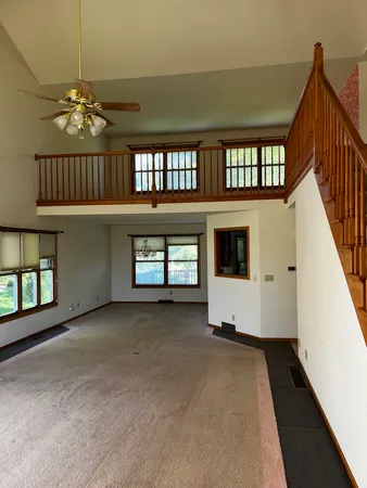 a view of an empty room with a window and fireplace