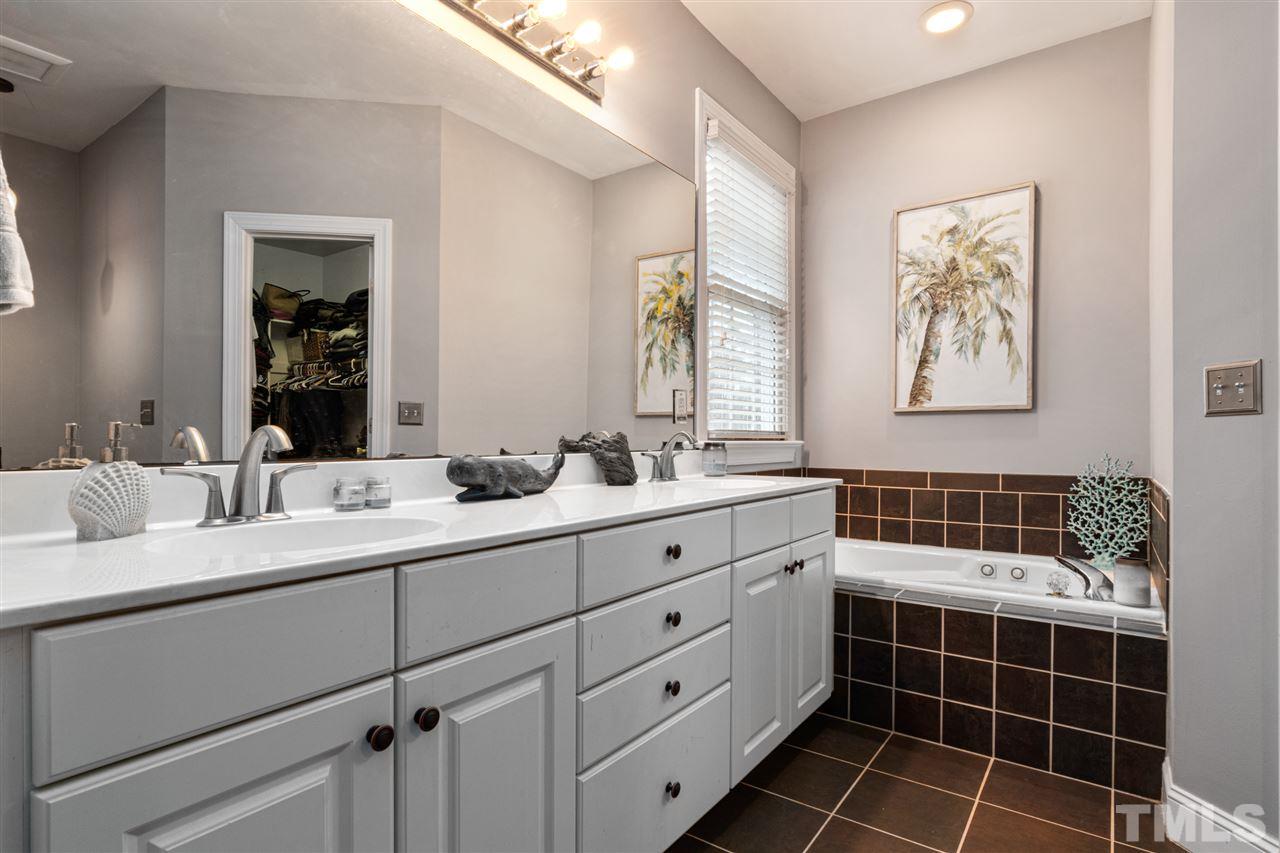 2408 Carruthers Court Raleigh, NC 27615 - Photo 15 of 30 a bathroom with a double vanity sink a mirror and a shower