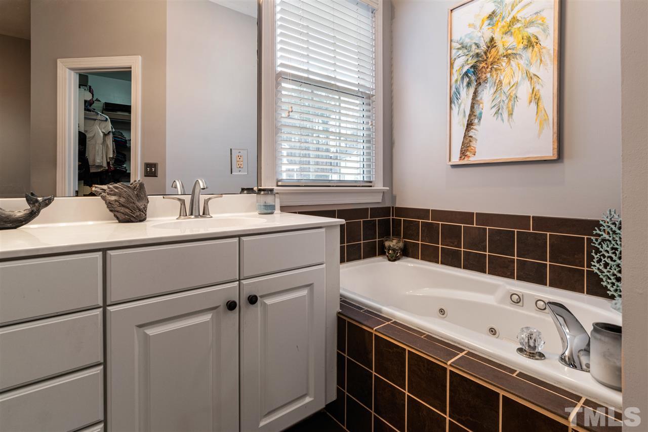 2408 Carruthers Court Raleigh, NC 27615 - Photo 17 of 30 a bathroom with a tub sink and mirror