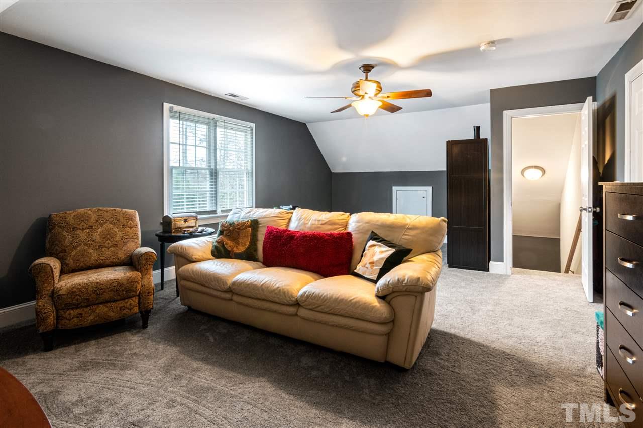 2408 Carruthers Court Raleigh, NC 27615 - Photo 22 of 30 a living room with a couch and a chandelier