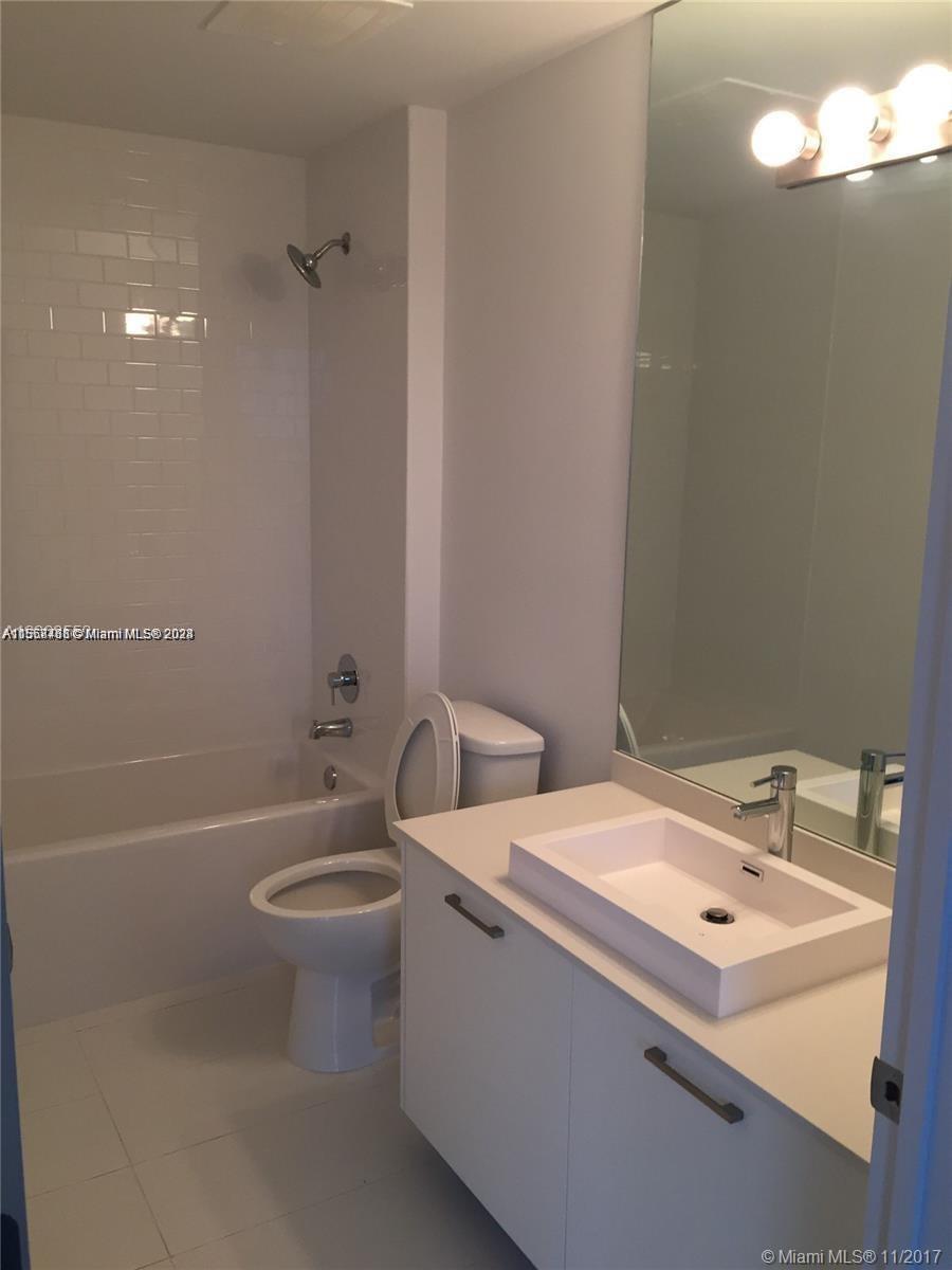 151 Southeast 1st Street, Unit 1505 Miami, FL 33131 - Photo 9 of 23 a bathroom with a sink a toilet and shower