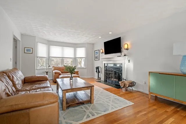 a living room with furniture a fireplace and a flat screen tv
