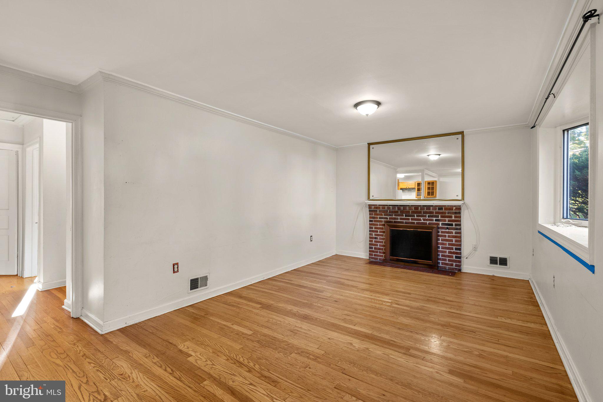 502 Lanark Way Silver Spring, MD 20901 - Photo 4 of 29 a view of empty room with wooden floor and fireplace
