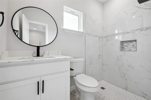 a bathroom with a sink a toilet and a mirror