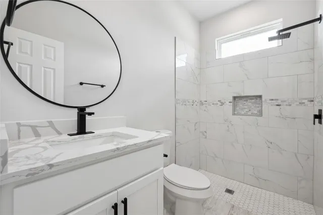 a bathroom with a sink a toilet and a mirror