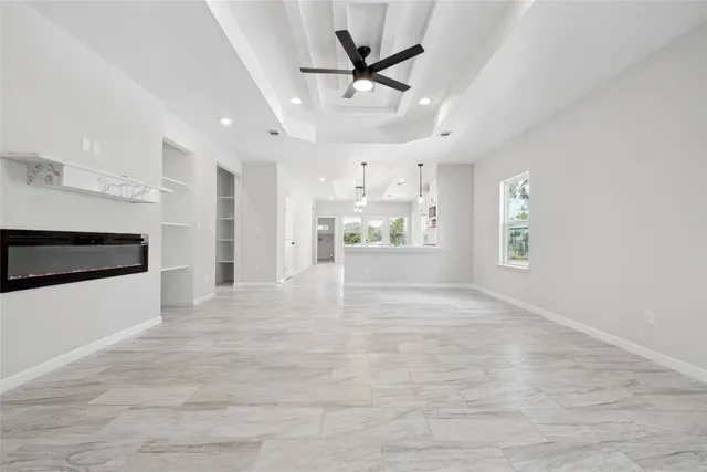 a view of an empty room and kitchen view