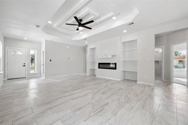 a view of empty room with wooden floor and window