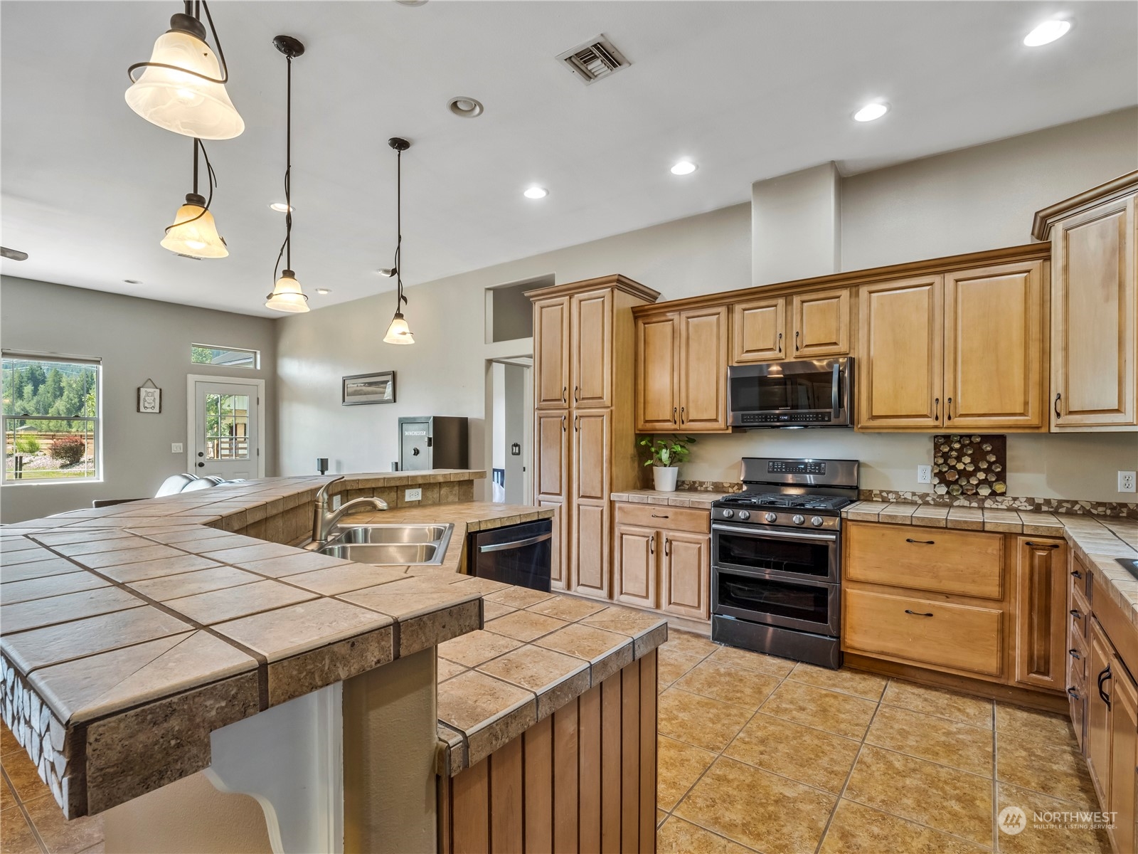 470 Old Cedars Road Cle Elum, WA 98922 - Photo 8 of 25 a kitchen with stainless steel appliances kitchen island granite countertop a stove and a sink
