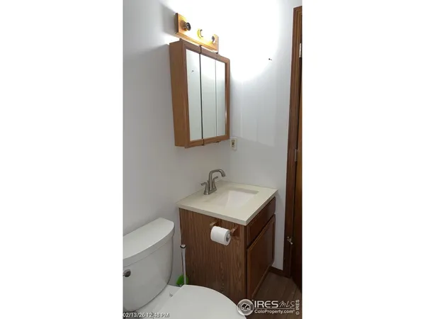 a bathroom with a toilet a sink and mirror