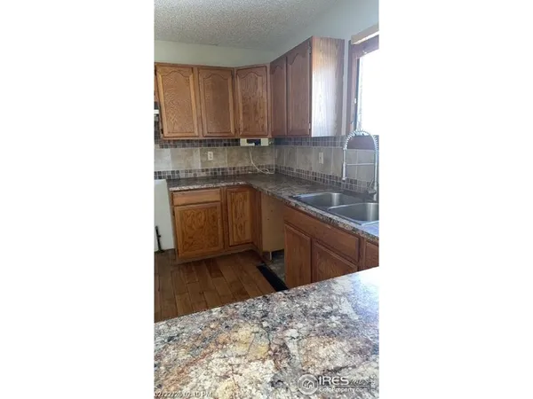 a kitchen with granite countertop sink and cabinets