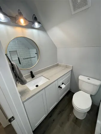 a bathroom with a toilet a sink and mirror