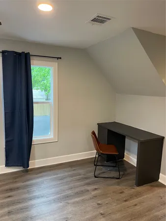 a workspace with wooden floor and a window