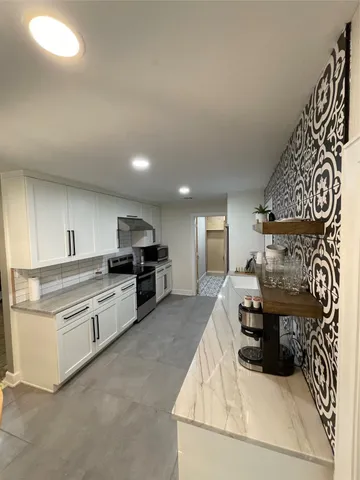 a kitchen with stainless steel appliances kitchen island granite countertop a stove and a sink