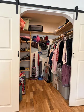 a view of walk in closet with clothes and shoes