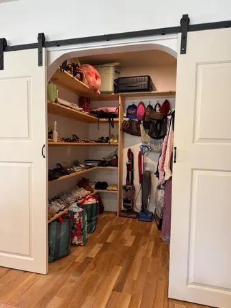 a view of walk in closet with clothes and shoes