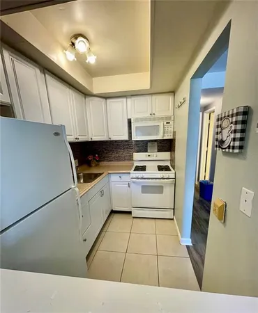 a kitchen with a white cabinets and white appliances