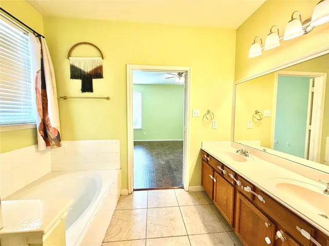 a bathroom with a tub sink and mirror