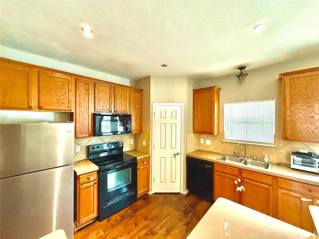 a kitchen with stainless steel appliances a refrigerator sink and cabinets
