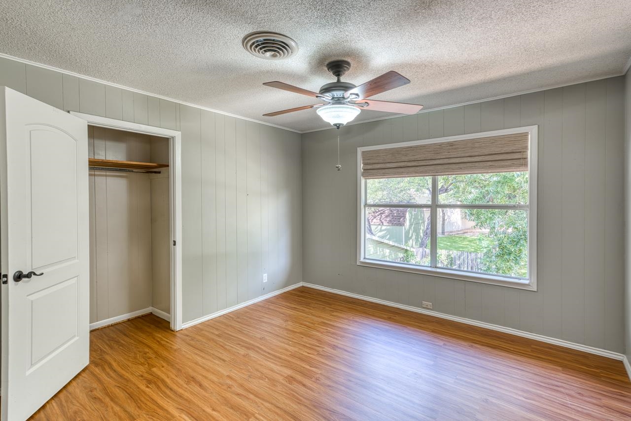 207 Princess Terrace Sunrise Beach, TX 78643 - Photo 11 of 25 a view of an empty room with wooden floor and a window