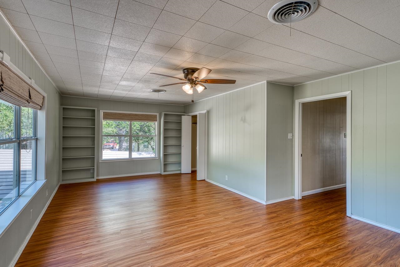 207 Princess Terrace Sunrise Beach, TX 78643 - Photo 14 of 25 a view of an empty room with a window and wooden floor