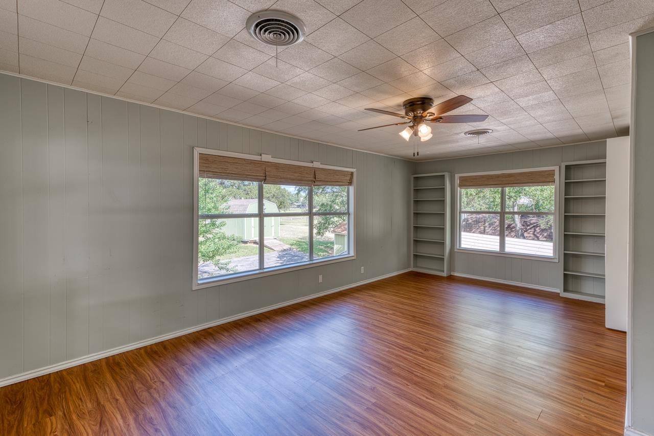 207 Princess Terrace Sunrise Beach, TX 78643 - Photo 15 of 25 an empty room with wooden floor and windows