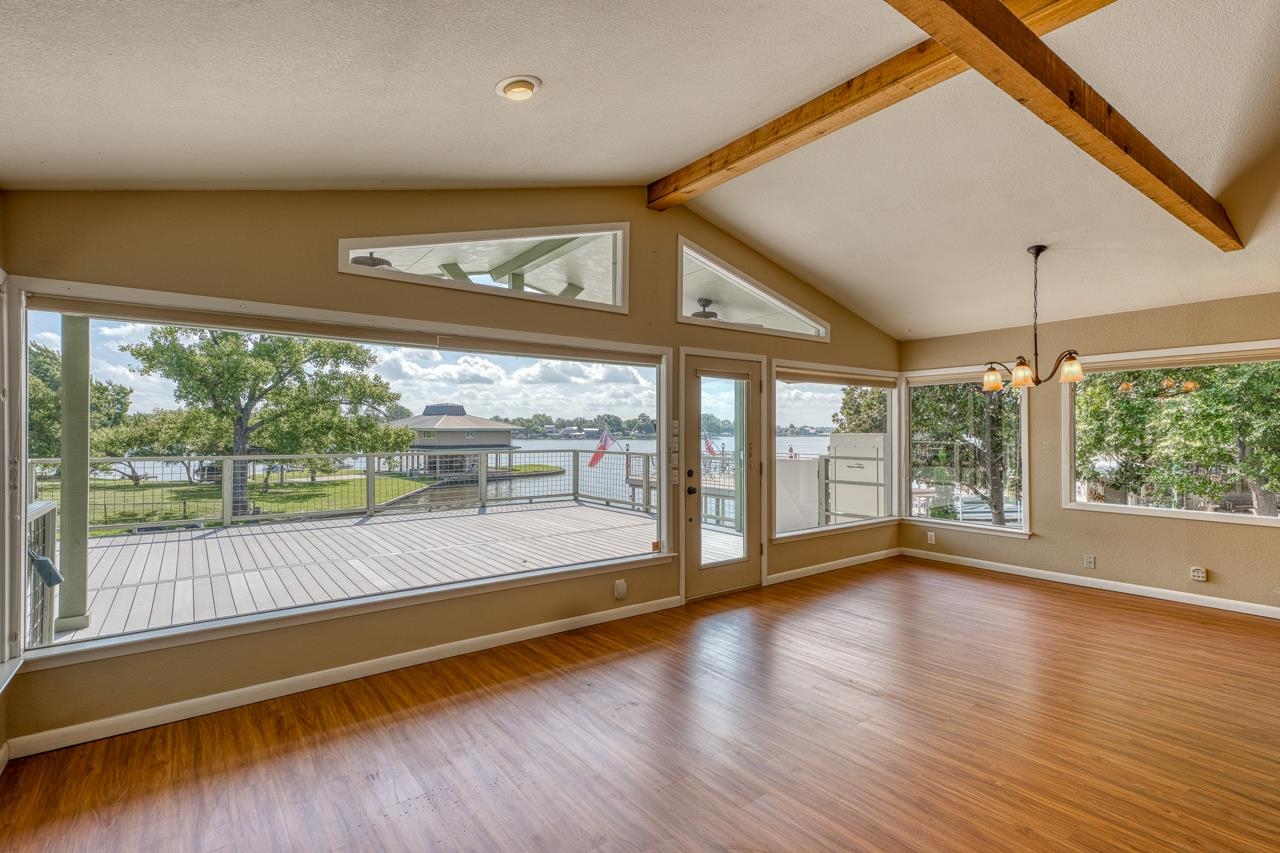 207 Princess Terrace Sunrise Beach, TX 78643 - Photo 7 of 25 a view of an empty room with wooden floor and a large window