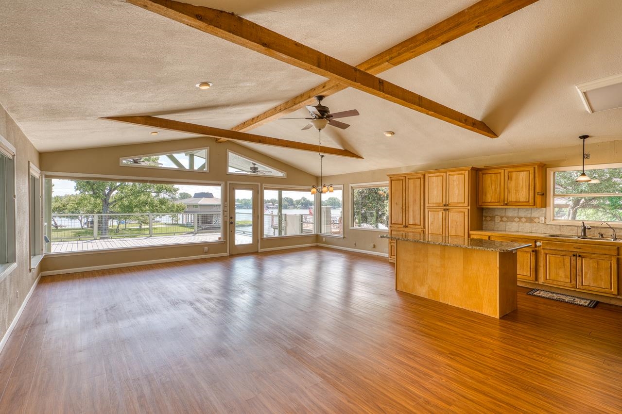 207 Princess Terrace Sunrise Beach, TX 78643 - Photo 10 of 25 a view of an empty room with wooden floor and a window