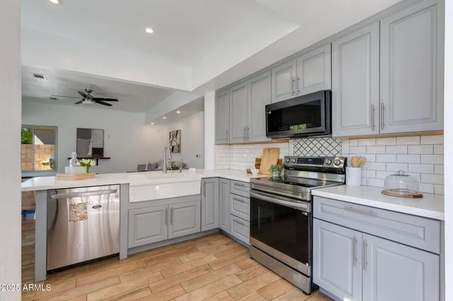 a kitchen with stainless steel appliances a refrigerator a stove a sink dishwasher and a refrigerator with wooden floor