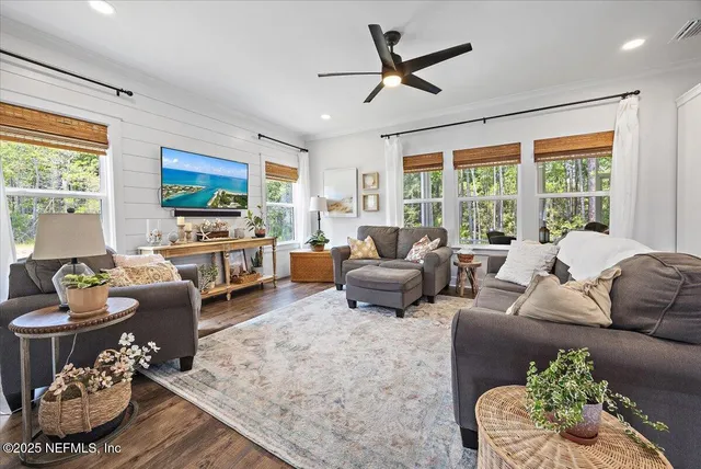 a living room with furniture flat screen tv and a large window