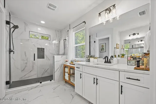 a bathroom with a shower sink and mirror