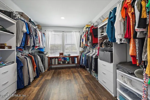 a view of walk in closet with clothes and shoes