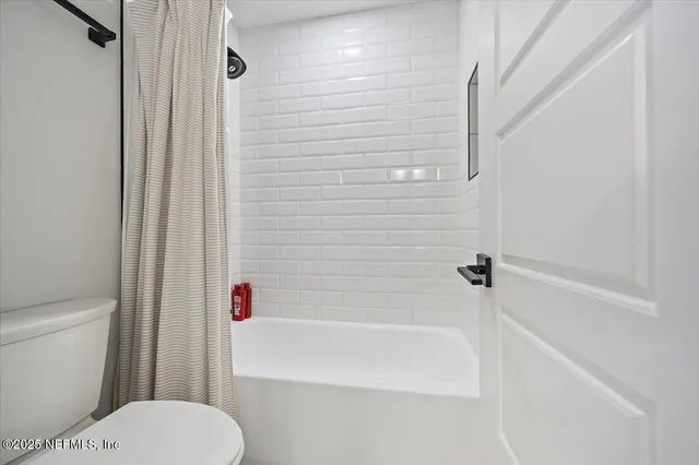 a white toilet sitting next to a bath tub