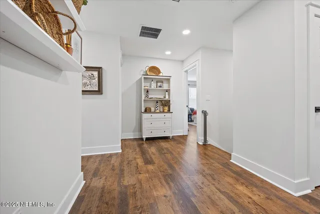 a view of a hallway with wooden floor and closet