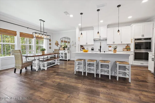 a dining room with furniture a chandelier and wooden floor