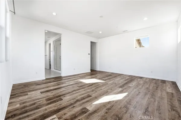 a view of an empty room with wooden floor