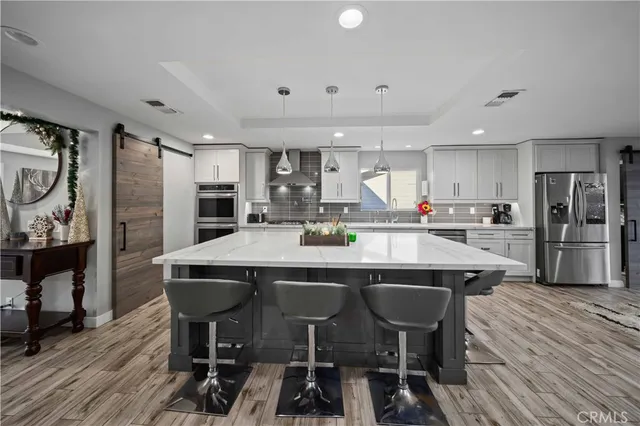 a large kitchen with kitchen island a sink stainless steel appliances and cabinets