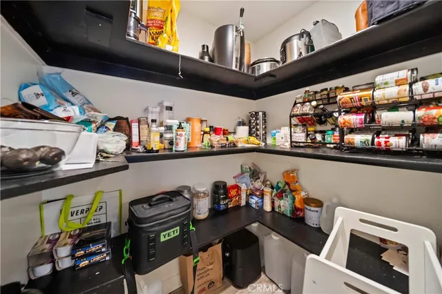 a living room with furniture kitchen view and a large window