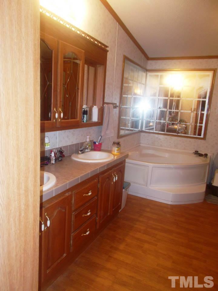 109 Medlin Road Rougemont, NC 27572 - Photo 2 of 19 a bathroom with a double vanity sink and mirror