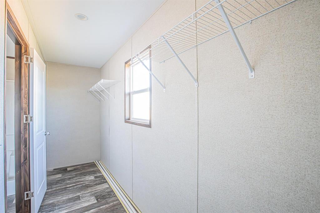 4127 Denver Road Sunset, TX 76270 - Photo 27 of 27 Walk-in closet featuring wire shelving, a window with wood trim, wood-finish flooring, and recessed ceiling lighting
